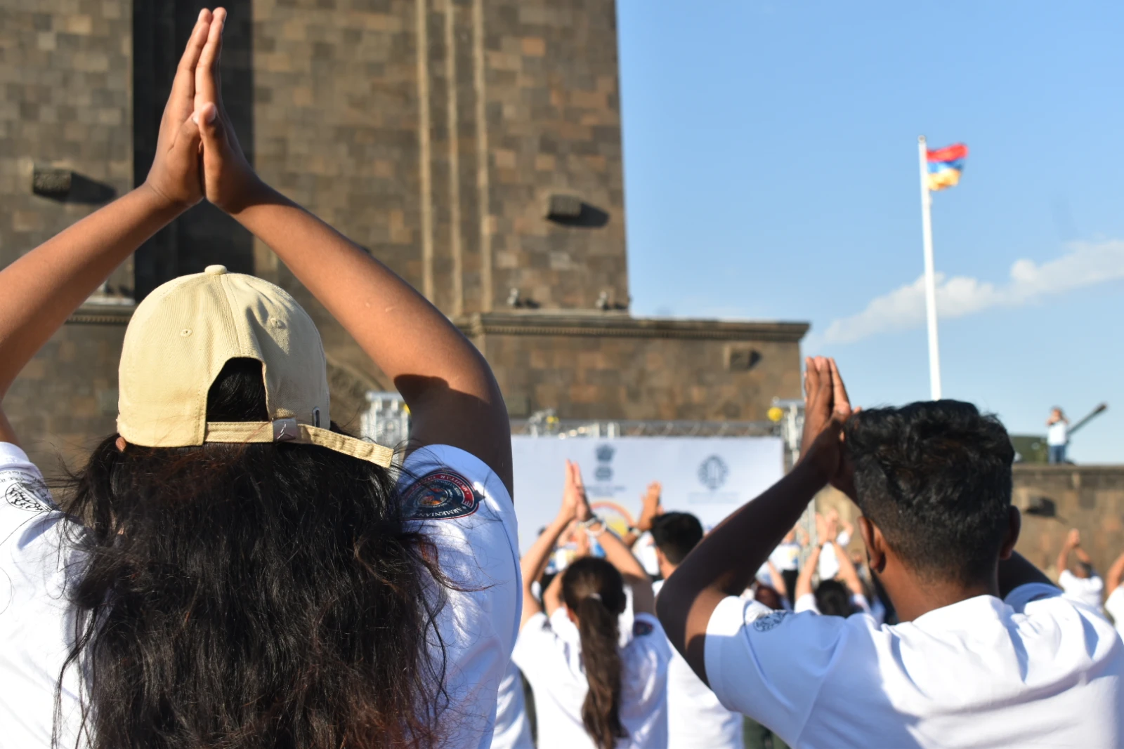 Participants practice yoga in front of the Mother Armenia statue. (PHOTO: Olivia Law)