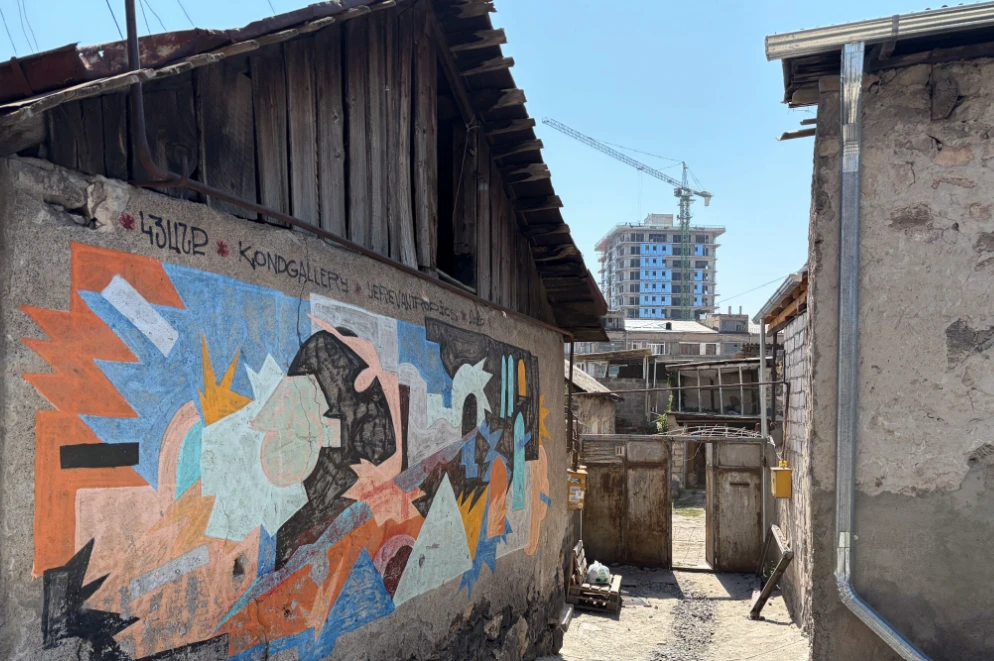 A mural by the Kondgallery street art project, with new construction behind it.
